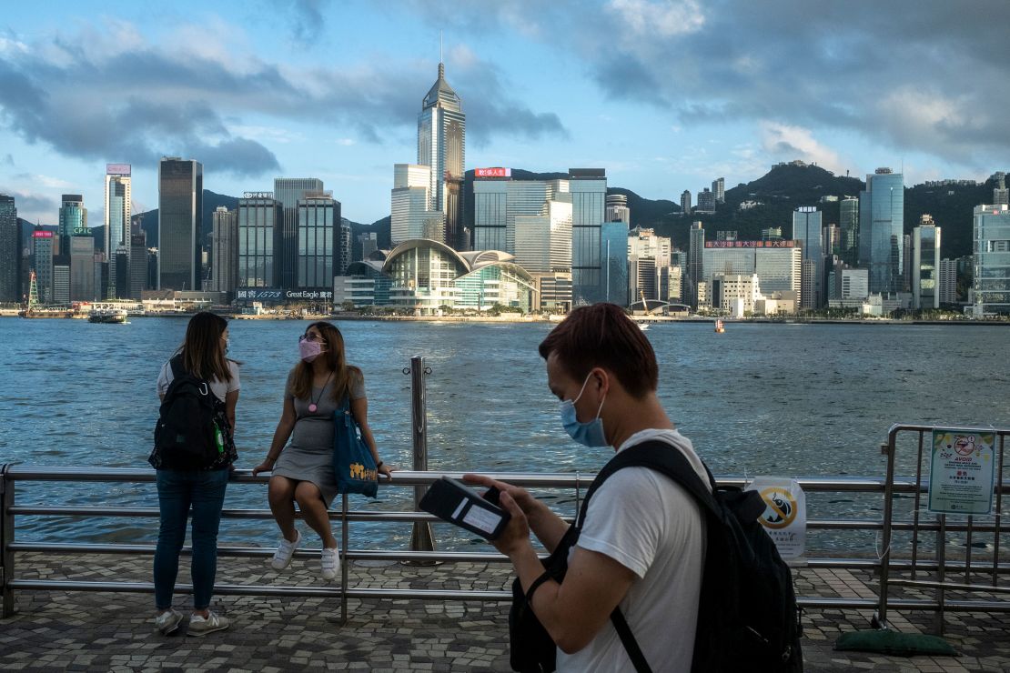 Pedestrians in front of the Hong Kong skyline in May.