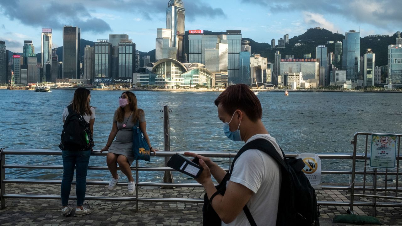 Pedestrians in front of the Hong Kong skyline in May.