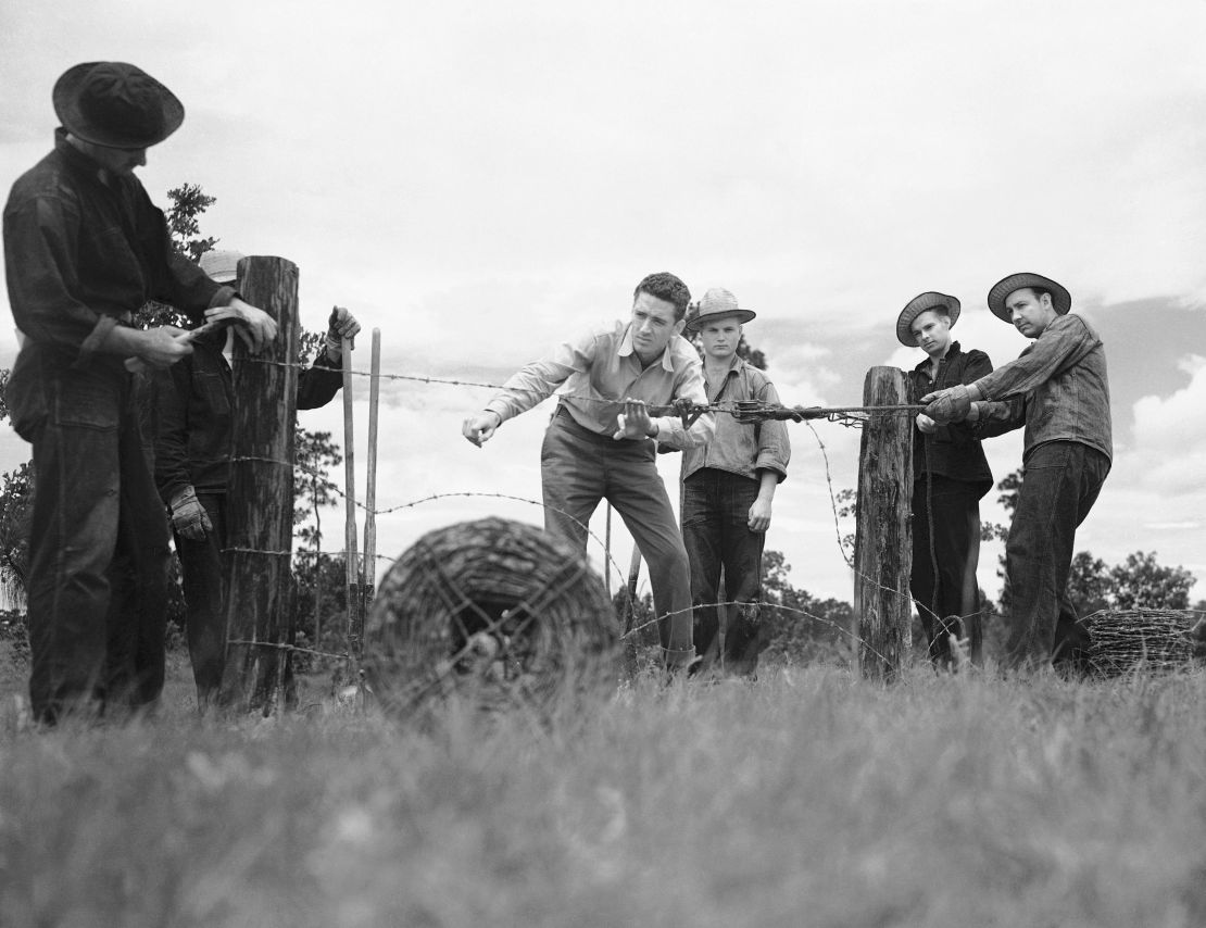 The Civilian Conservation Corps was a public work relief program for young men, providing unskilled manual labor related to the conservation and development of natural resources in rural areas. Here, a group erects a fence on July 26, 1940.