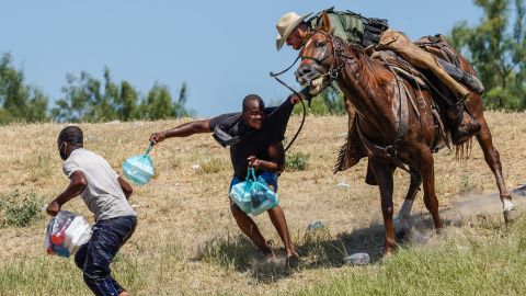 A US Border Patrol agent on horseback tries to stop a Haitian migrant from entering an encampment on the banks of the Rio Grande near the Acuna Del Rio International Bridge in Del Rio, Texas, on September 19, 2021.
