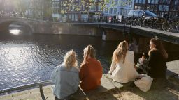 AMSTERDAM, NETHERLANDS - APRIL 01: Residents sit in the sun on a canal amid the third wave of the Coronavirus pandemic on April 1, 2021 in Amsterdam, Netherlands. (Photo by Pierre Crom/Getty Images)