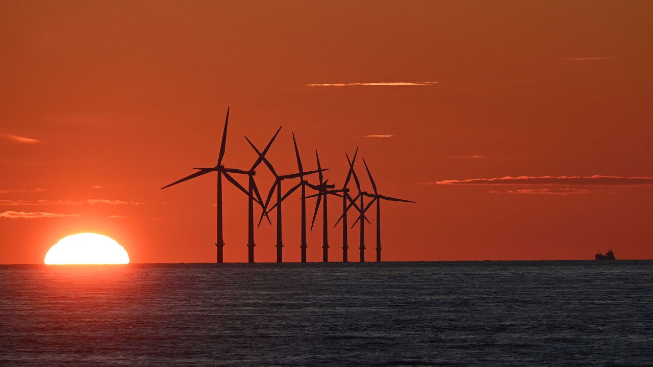 The sun sets behind the Burbo Bank offshore wind farm in Liverpool Bay, northwest England, in May 2021.