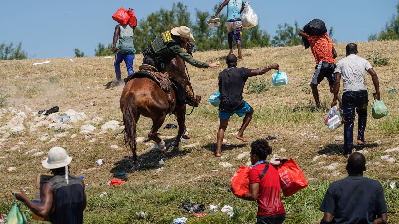 A United States Border Patrol agent on horseback tries to stop a Haitian migrant from entering an encampment on the banks of the Rio Grande in Del Rio, Texas, on Sept. 19, 2021.
