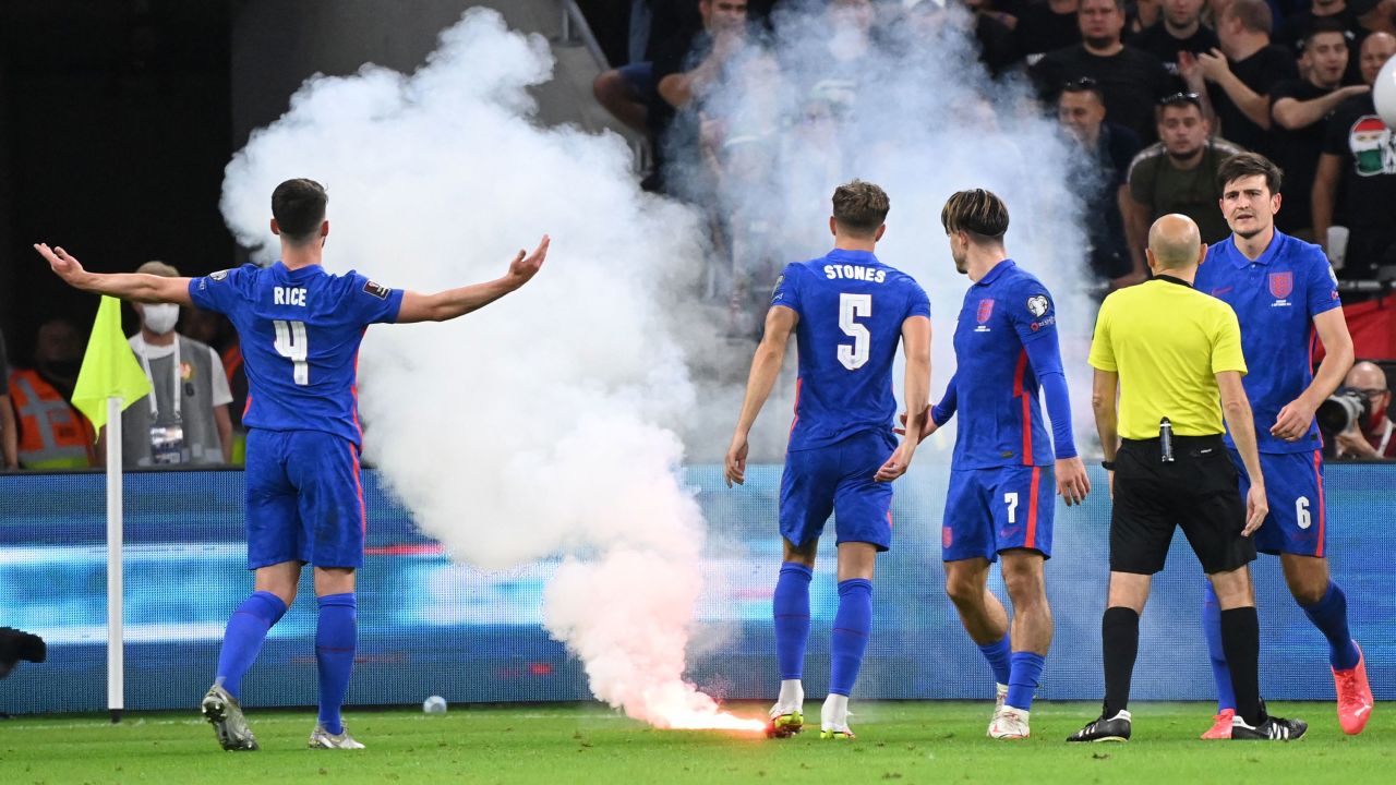 Players react as the game needs to be interrupted due to flares landing on the pitch.