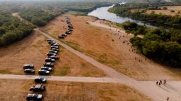 Official vehicles line up along the bank of the Rio Grande near an encampment of migrants, many from Haiti, near the Del Rio International Bridge, on Sept. 21, 2021, in Del Rio, Texas. The U.S. is flying Haitians camped in a Texas border town back to their homeland and blocking others from crossing the border from Mexico