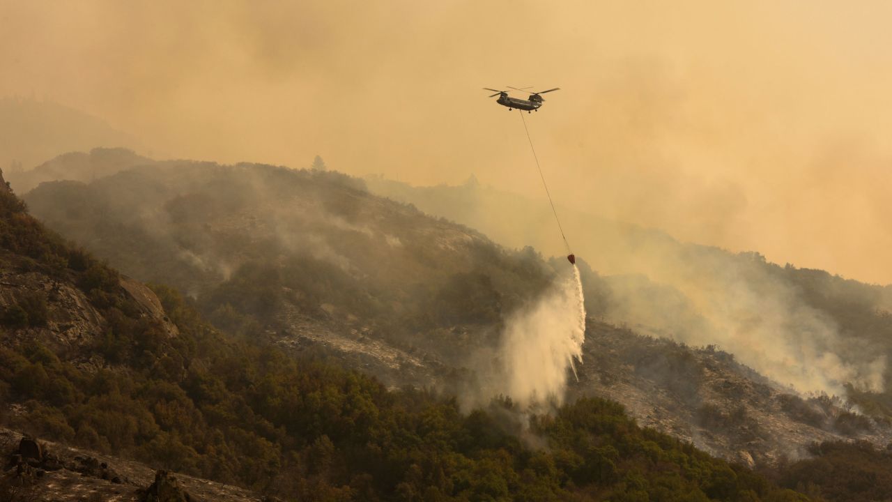 A Chinook firefighting helicopter carries water to drop on the fire as the KNP Complex fire in the Sequoia National Park continues to rage.