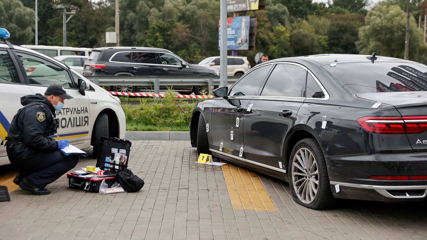 An investigator examines bullet holes in the car of Serhiy Shefir, aide to Ukraine's President.