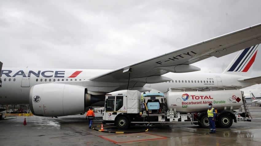 Workers refuel an Airbus A350 with sustainable aviation fuel at Roissy airport, north of Paris, on May 18, 2021. Air France-KLM is sending into the air what it calls its first long-haul flight with sustainable aviation fuel Tuesday. The plane is said to be using petroleum mixed with a synthetic jet fuel derived from waste cooking oils.