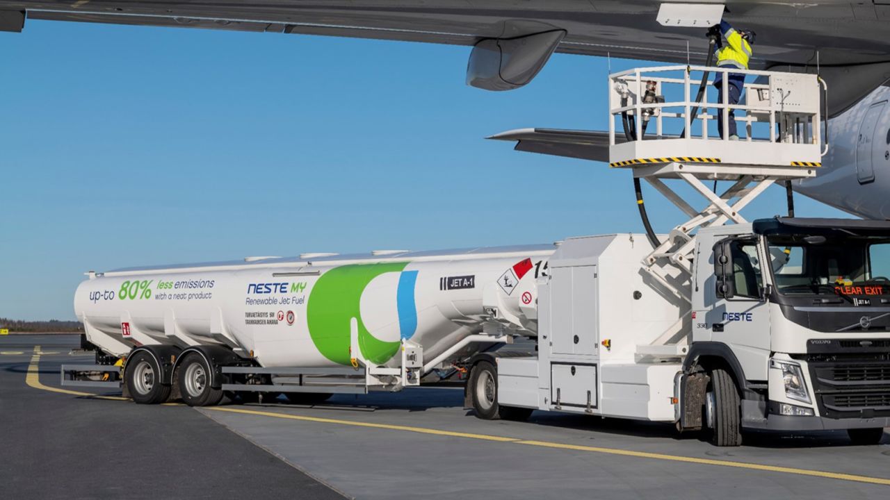 A tanker truck fuels a plane with SAF produced by Finland's Neste at Helsinki Airport.