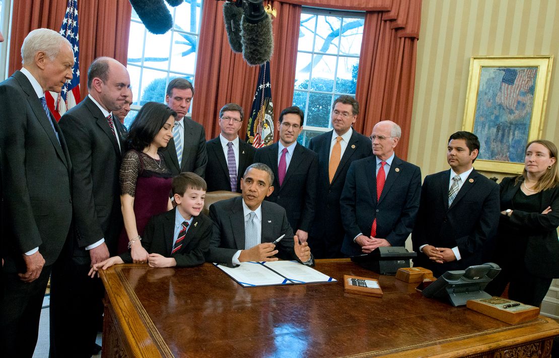 In this April 3, 2014, file photo, President Barack Obama signs H.R. 2019, the Gabriella Miller Kids First Research Act, in the Oval Office of the White House. From left to right:  Sen. Orrin Hatch (R-Utah); Mark Miller, father of Gabriella; Sen. Tim Kaine (D-VA); Ellyn Miller; Sen. Mark Warner (D-VA); Jacob Miller, brother of Gabriella; Mike Gillette, Miller family friend; House Majority Leader Eric Cantor (R-VA); Rep. Gregg Harper (R-MS); Rep. Peter Welch (D-VT); Rep. Raul Ruiz (D-CA); and Nancy Goodman.
