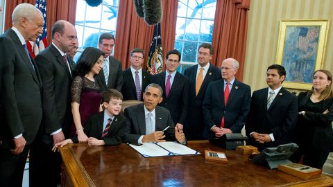 In this April 3, 2014, file photo, President Barack Obama signs H.R. 2019, the Gabriella Miller Kids First Research Act, in the Oval Office of the White House. From left to right:  Sen. Orrin Hatch (R-Utah); Mark Miller, father of Gabriella; Sen. Tim Kaine (D-VA); Ellyn Miller; Sen. Mark Warner (D-VA); Jacob Miller, brother of Gabriella; Mike Gillette, Miller family friend; House Majority Leader Eric Cantor (R-VA); Rep. Gregg Harper (R-MS); Rep. Peter Welch (D-VT); Rep. Raul Ruiz (D-CA); and Nancy Goodman.