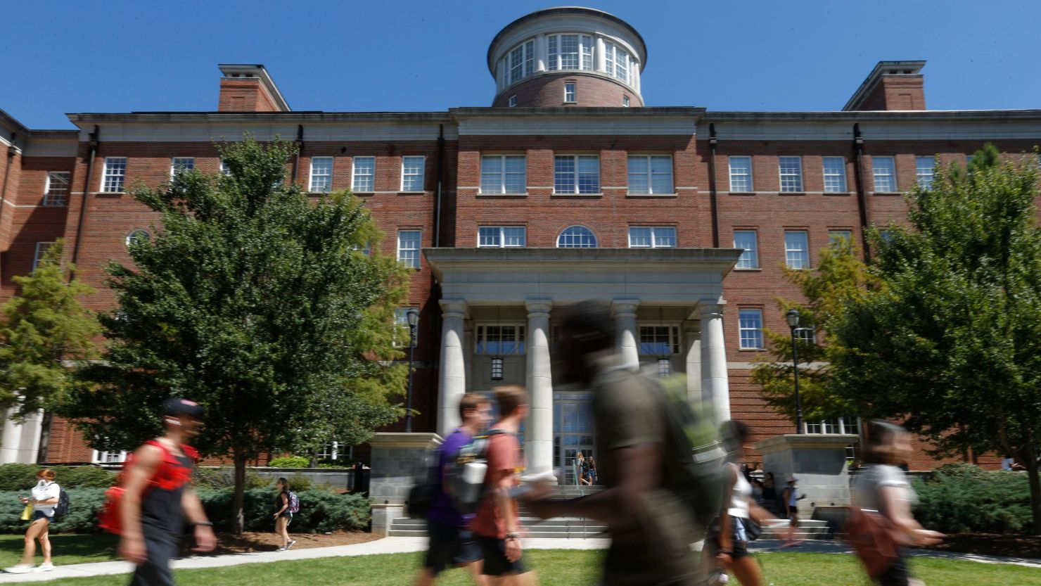 Students walk near the Miller Learning Center on the first day of classes of the fall semester at the University of Georgia in Athens on August 18, 2021.