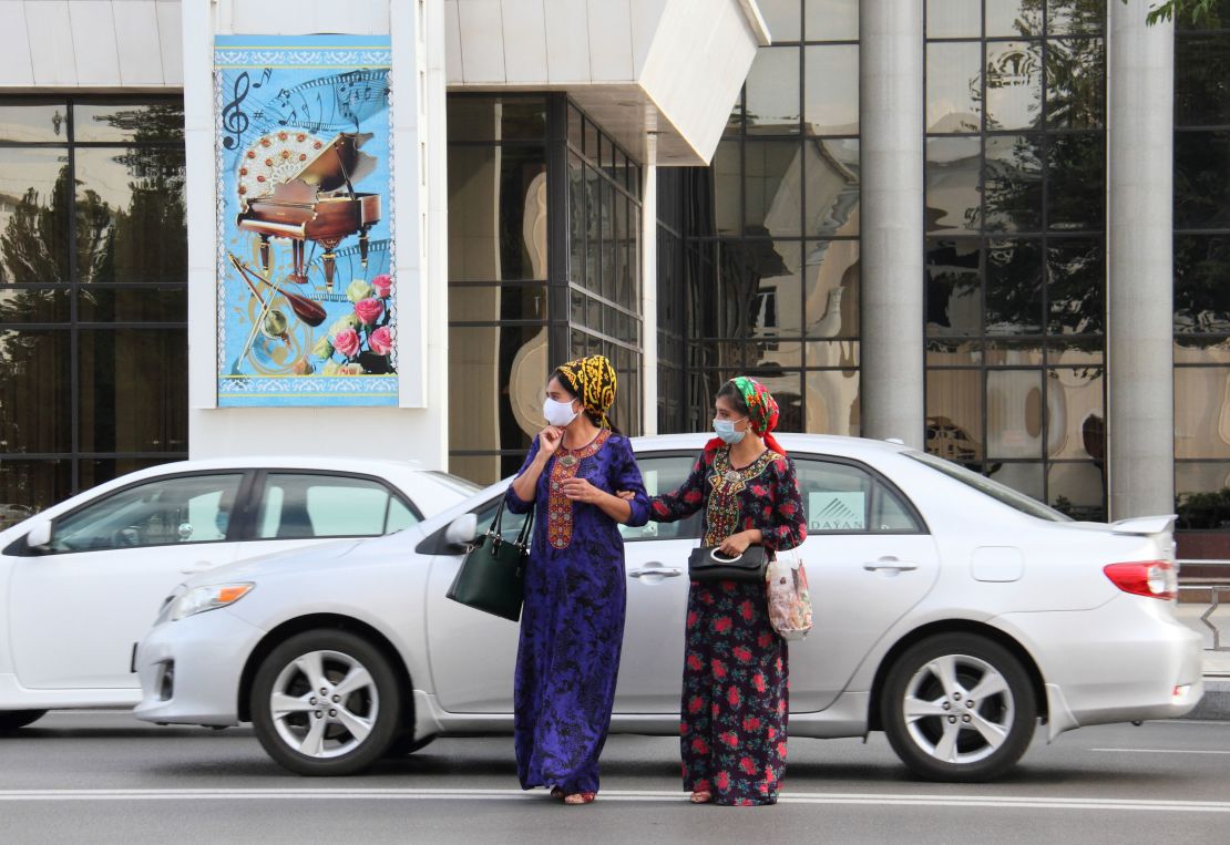 Women wearing protective face masks cross a road in Ashgabat, Turkmenistan, on July 15, 2020. 