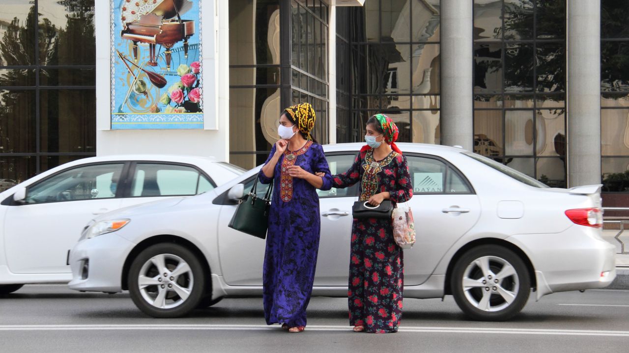 Women wearing protective face masks cross a road in Ashgabat, Turkmenistan, on July 15, 2020.