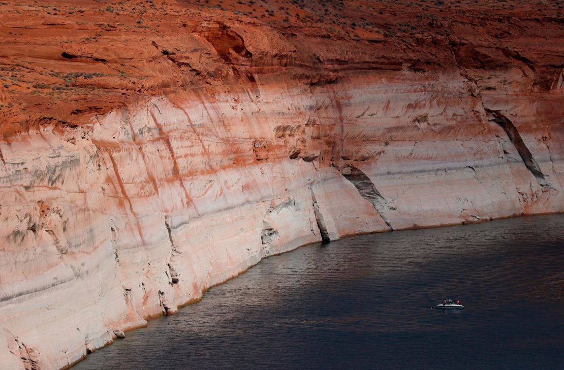 In this aerial view, a boat is dwarfed by the tall bleached "bathtub ring" on the rocky banks of Lake Powell on June 24, 2021, in Page, Arizona. 