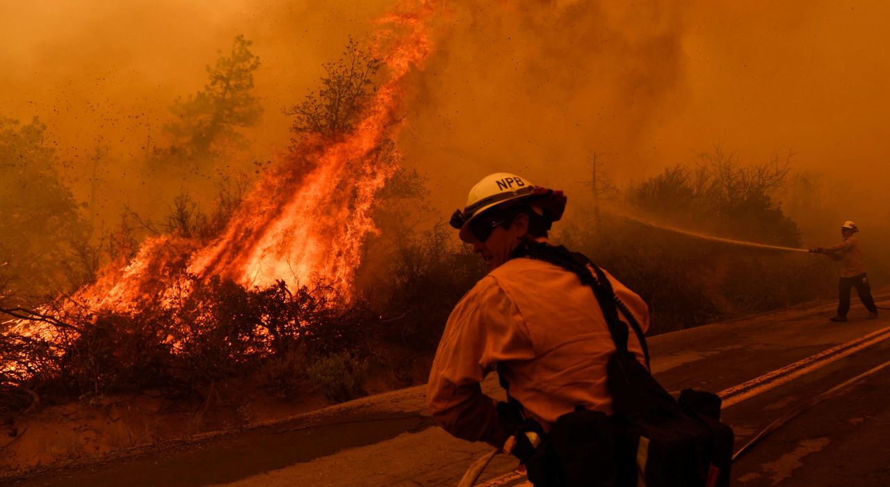 Firefighters spray water as flames from the Windy Fire push toward a road in California's Sequoia National Forest on September 22.
