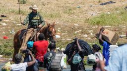TOPSHOT - A United States Border Patrol agent on horseback uses the reins as he tries to stop Haitian migrants from entering an encampment on the banks of the Rio Grande near the Acuna Del Rio International Bridge in Del Rio, Texas on September 19, 2021. - The United States said Saturday it would ramp up deportation flights for thousands of migrants who flooded into the Texas border city of Del Rio, as authorities scramble to alleviate a burgeoning crisis for President Joe Biden's administration. (Photo by PAUL RATJE / AFP) (Photo by PAUL RATJE/AFP via Getty Images)