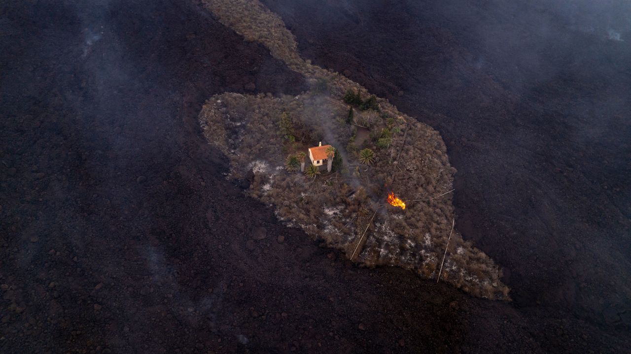 A house remains intact on Monday, September 20, as lava flows after a volcano erupted a day earlier in La Palma, one of Spain's Canary Islands. <a href="https://www.cnn.com/2021/09/23/europe/spain-canaries-volcano-ash-blanket-intl/index.html" target="_blank">According to Reuters,</a> streams of black lava advanced slowly westward since the Cumbre Vieja volcano erupted, forcing thousands of people to flee and incinerating houses, schools and the banana plantations that produce the island's biggest export.