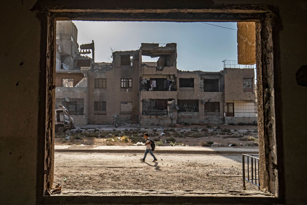 A student walks to school past damaged buildings in Raqqa, Syria, on Thursday, September 23.