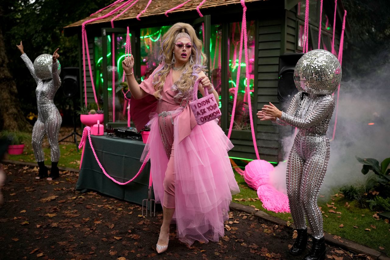 Daisy the Drag Queen Gardener dances next to performers wearing disco ball heads at the Royal Horticultural Society Chelsea Flower Show in London on Monday, September 20.