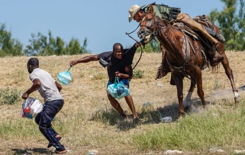 A US Border Patrol agent on horseback tries to stop migrants on the banks of the Rio Grande near the Del Rio International Bridge in Del Rio, Texas, on Sunday, September 19.