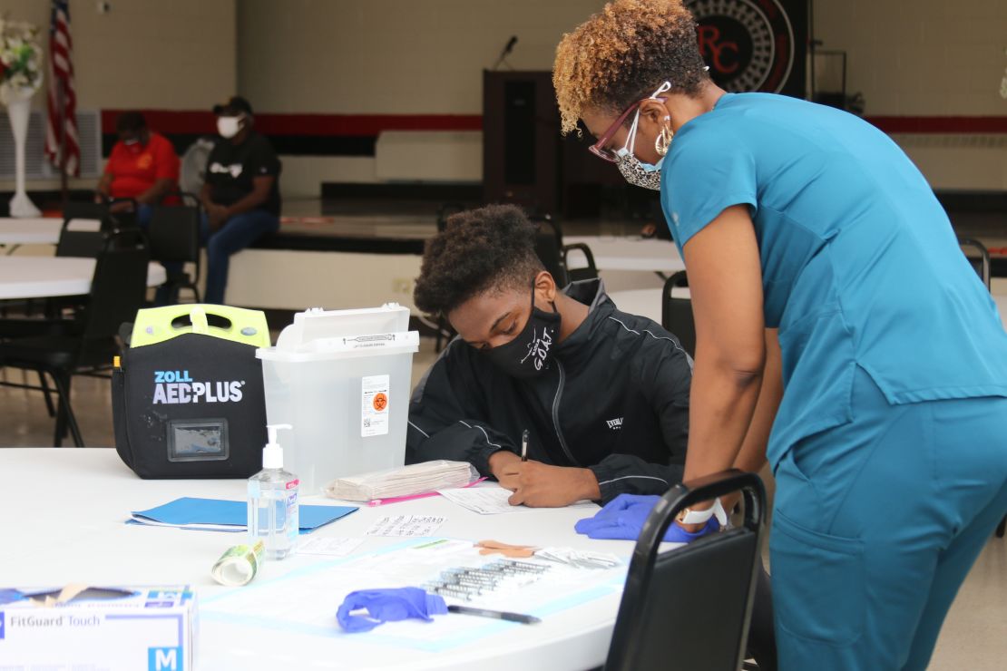 At a teen-focused Covid-19 vaccine clinic, 15-year-old Raymond Slaughter fills out his paperwork before getting his first shot.