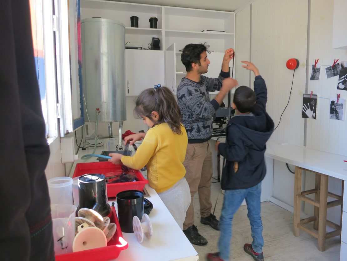 Co-founder Serbest Salih with students inside the mobile darkroom.
