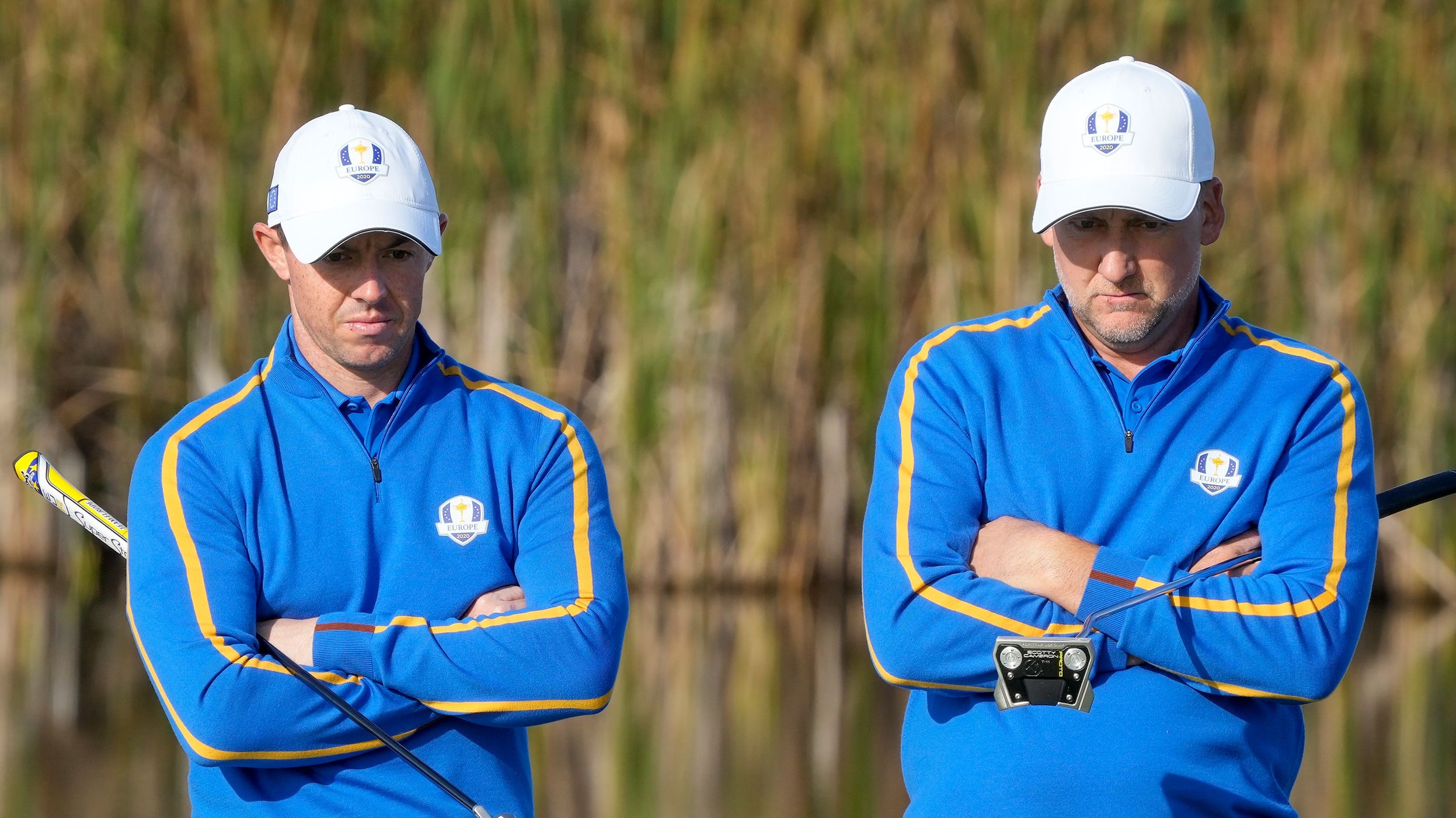Team Europe's Rory McIlroy and Ian Poulter wait to putt on the fifth hole.