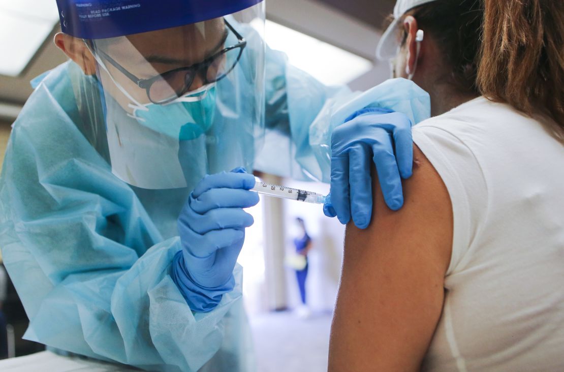 A nurse administers a flu vaccination shot to a woman at a free clinic held at a local library in Lakewood, California, on October 14, 2020.