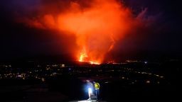 Two people walk as lava spews from a volcano on the Canary island of La Palma, Spain (AP Photo/Daniel Roca)