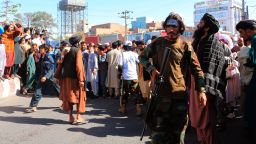 People gather in the main square of Herat city in western Afghanistan, where the Taliban hanged a dead body from a crane. The Taliban announced in the square that the four were caught taking part in a kidnapping and were killed by police. (AP Photo)