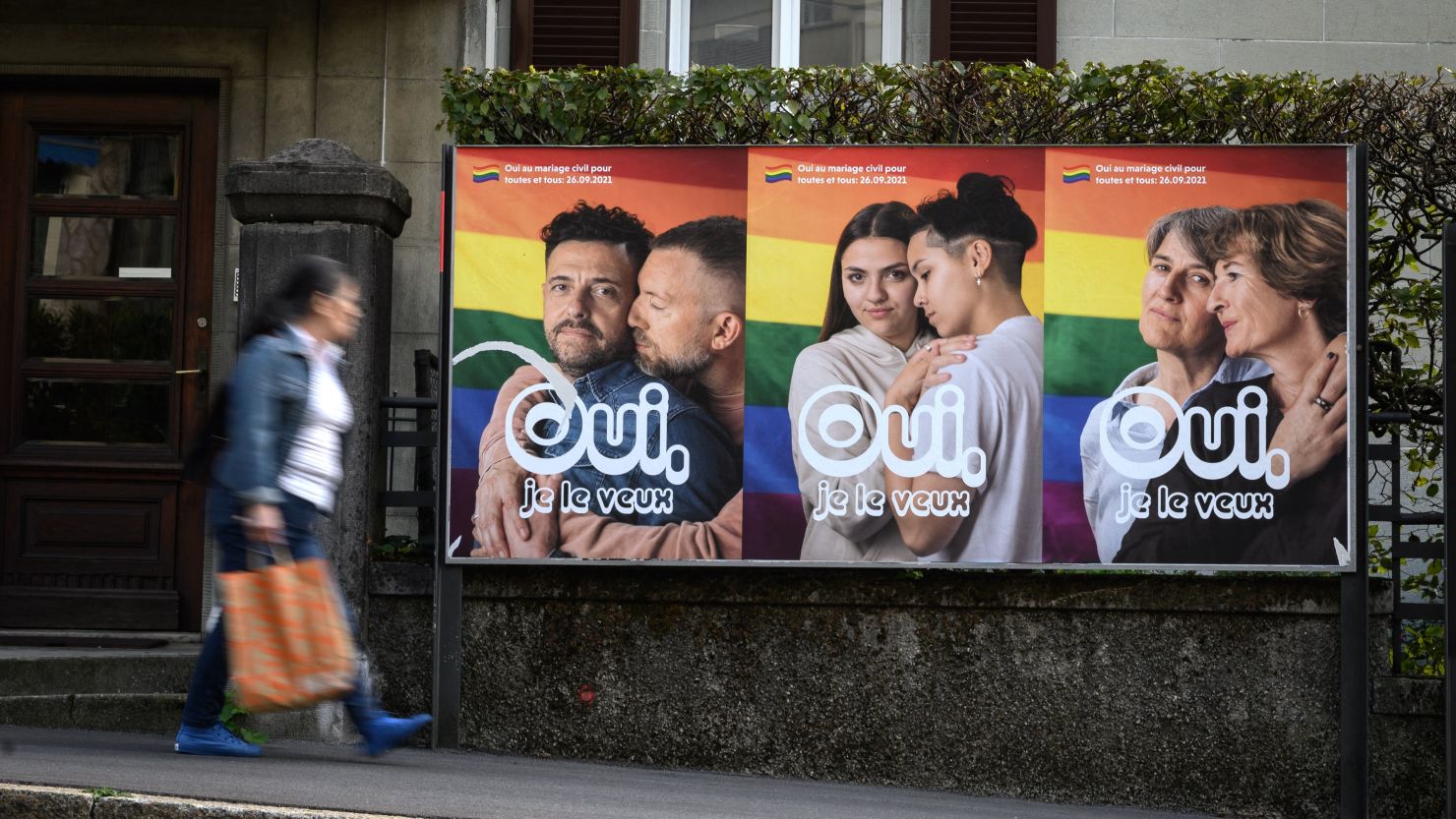 A woman walks past an electoral poster reading in French: "Yes I want it" ahead of a nationwide vote on marriage for all, on September 22, 2021 in Lausanne, Switzerland. 