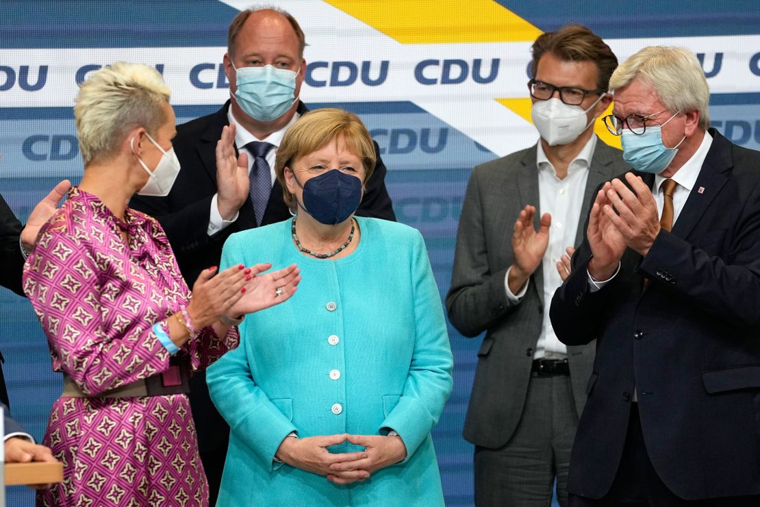 German Chancellor Angela Merkel stands as leading CDU members applaud on Sunday.