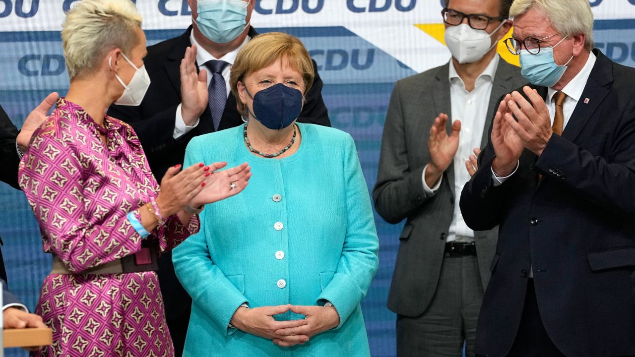German Chancellor Angela Merkel stands as leading CDU members applaud on Sunday.