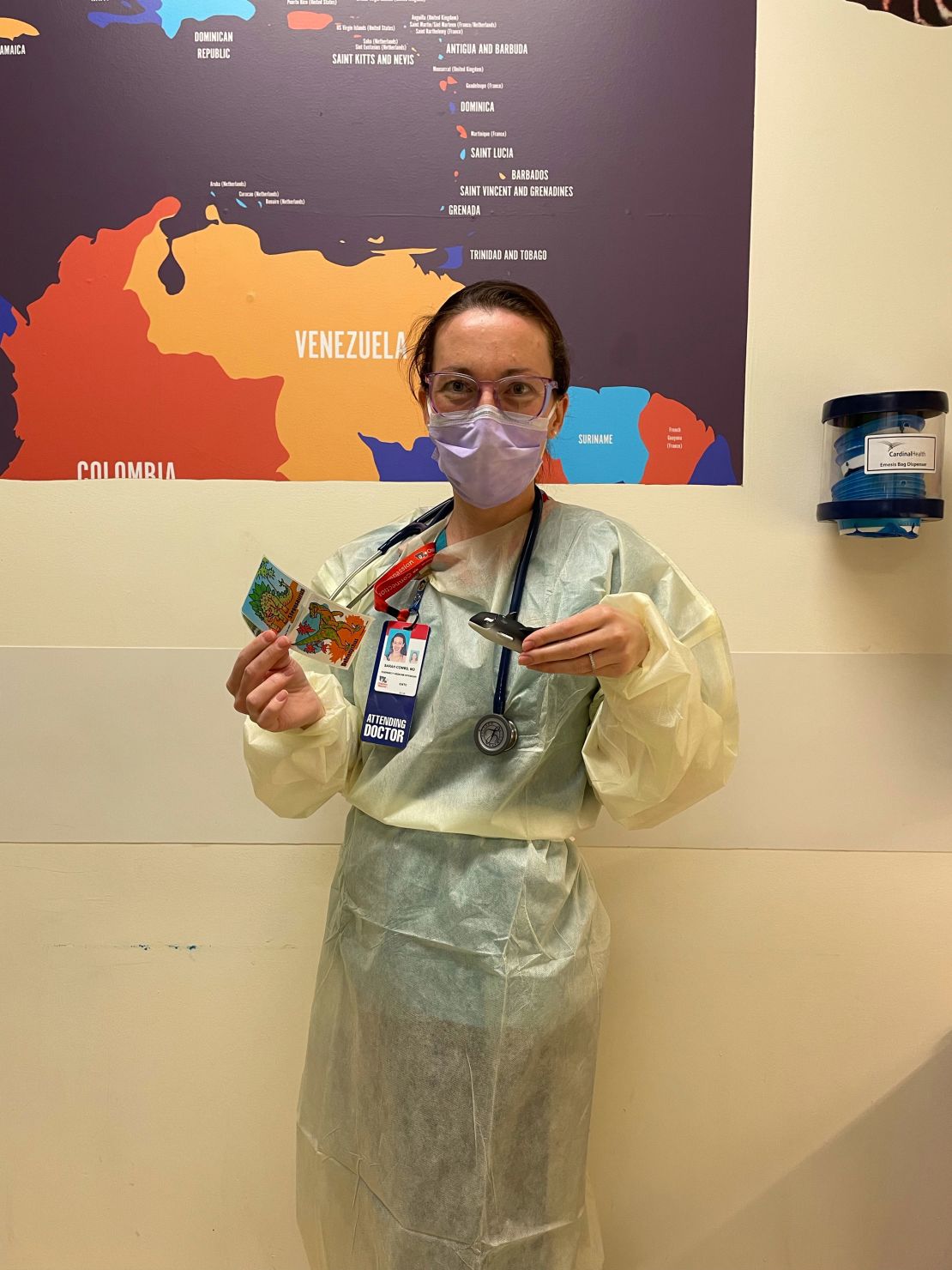 Dr. Sarah Ash Combs holds up stickers and an orca whale.