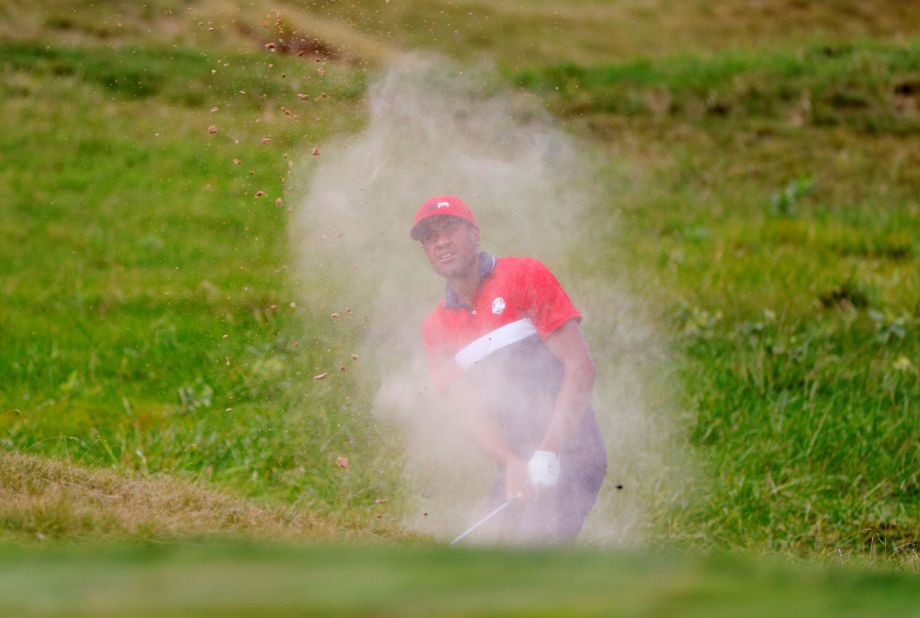 Team US' Tony Finau plays out from the bunker on the first hole.