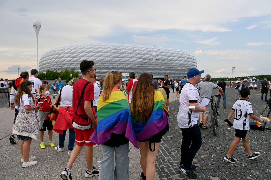 Fans wearing the rainbow flag outside of the Allianz Arena at Euro 2020