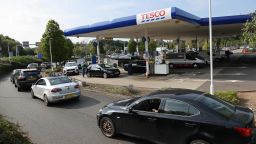 A line of vehicles queue to fill up at a Tesco petrol station in Camberley, west of London on September 26, 2021. - Britain's transport secretary Grant Shapps on Sunday accused lorry industry representatives of helping to spark petrol panic-buying, as he defended a U-turn on post-Brexit immigration policy to ease an escalating supply crisis. (Photo by Adrian DENNIS / AFP) (Photo by ADRIAN DENNIS/AFP via Getty Images)