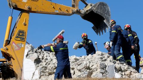 Firefighters look for people in the rubble of a demolished church following the quake.
