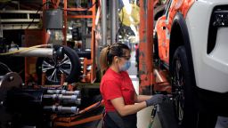 A worker wearing a protective mask installs wheels on a vehicle on the assembly line at the Nissan Motor Co. manufacturing facility in Smyrna, Tennessee, U.S., on Tuesday, May 18, 2021. Markit is scheduled to release manufacturing figures on May 21. 