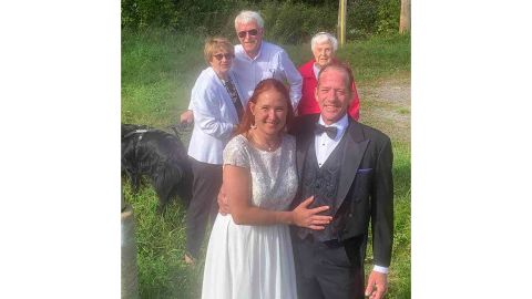The couple smiles shortly after the ceremony, with her family -- on the other side of the border, in Canada -- smiling in the background.