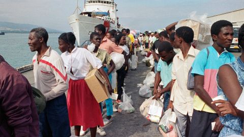 Haitian refugees disembark from a US Coast Guard vessel in February 1992 after being  deported from Guantanamo Bay, Cuba.