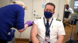 CHICAGO, ILLINOIS - MARCH 09: United Airlines pilot Steve Lindland receives a COVID-19 vaccine from RN Sandra Manella at United's onsite clinic at O'Hare International Airport on March 09, 2021 in Chicago, Illinois. United has been vaccinating about 250 of their O'Hare employees at the clinic each day for the past several days.   (Photo by Scott Olson/Getty Images)