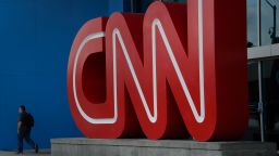 A pedestrian passes in front of CNN signage displayed at the network's headquarters building in Atlanta, Georgia, U.S., on Friday, Aug. 1, 2014. Time Warner is a "long, long way from a transaction," former Chief Executive Officer Richard Parsons said, adding the home of HBO, CNN and the Warner Bros. studio would be better off remaining independent. Photographer: Michael A. Schwarz/Bloomberg via Getty Images