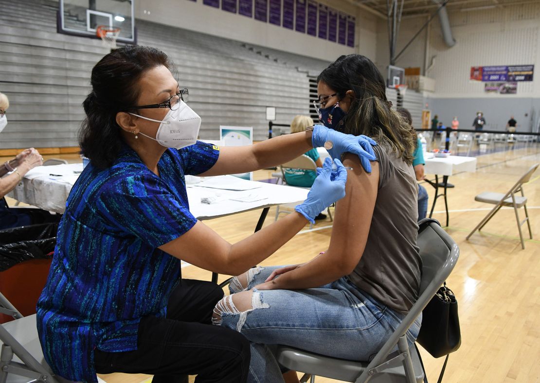 Nurse Susanna Bryan gives a dose of the Pfizer/BioNTech vaccine at Winter Springs High School in Florida.