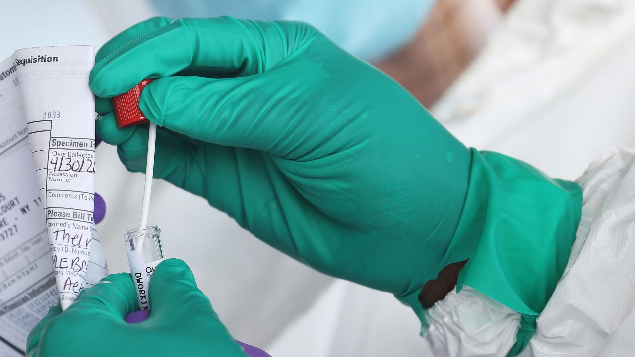 A Health Care Worker seals a coronavirus test swab.
