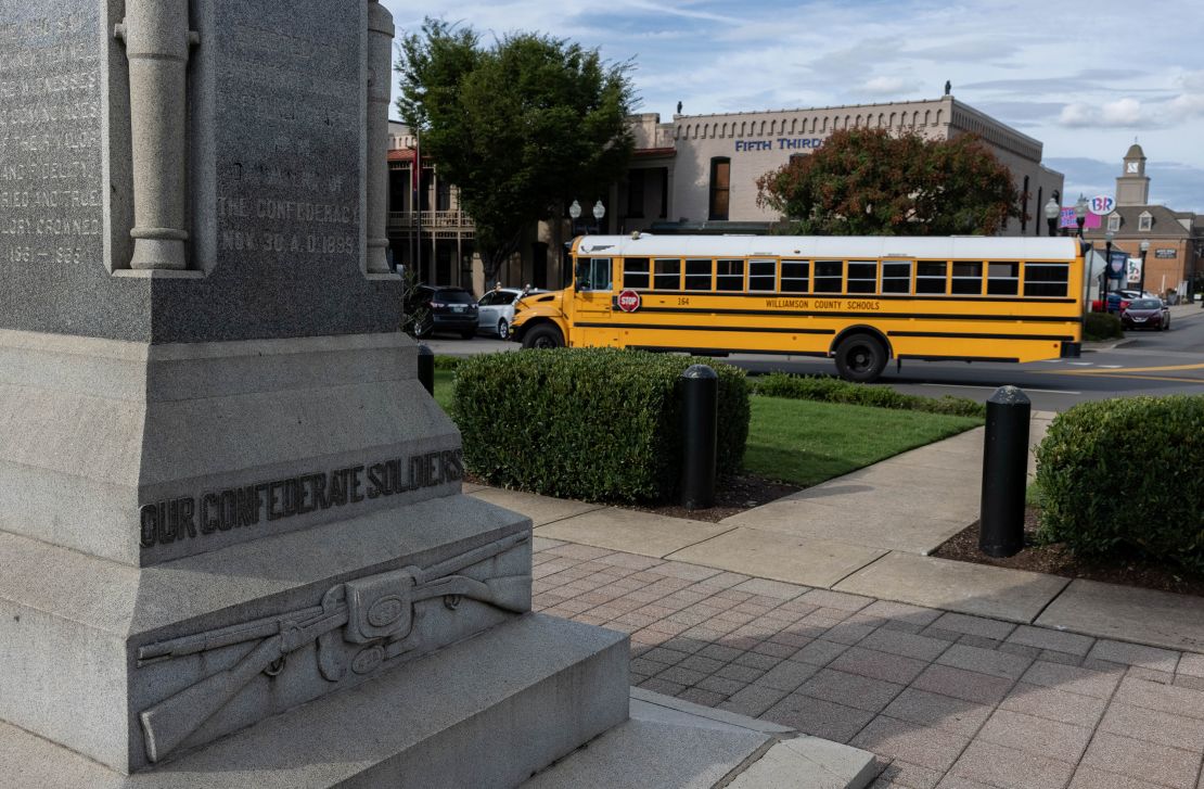 A Williamson County School bus drives past the Confederate monument which stands in the center of the town square in Franklin, Tennessee.