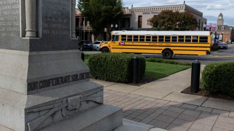 A Williamson County School bus drives past the Confederate monument which stands in the center of the town square in Franklin, Tennessee.