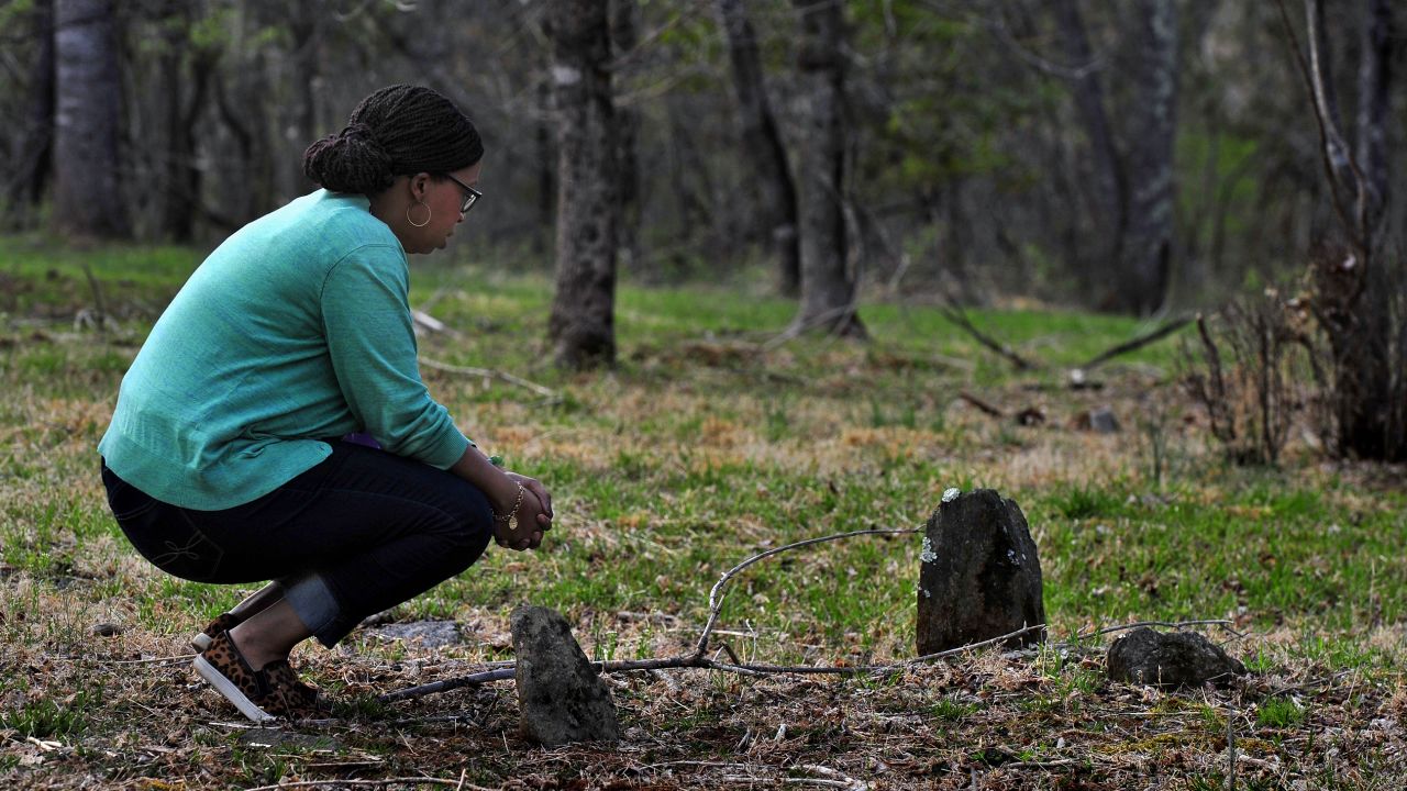 Bethany Pace  kneels at the simple stone monuments that mark the graves of slaves that were her kin, in Sweet Briar, Virginia, in 2015.
