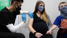 Aubrie Cusumano, who is 39 weeks pregnant, receives the Pfizer-BioNTech vaccine against the coronavirus disease (COVID-19) while holding her son, Luca's hand at Skippack Pharmacy in Schwenksville, Pennsylvania, U.S., February 11, 2021.  REUTERS/Hannah Beier